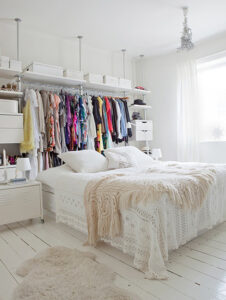Clothes rack hanging above bed.