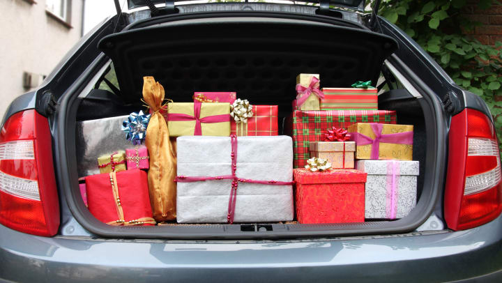A trunk of a car filled with Christmas presents.