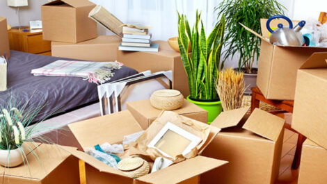 A bedroom cluttered with moving boxes.