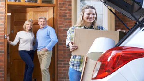 A college student loading moving boxes into her car.