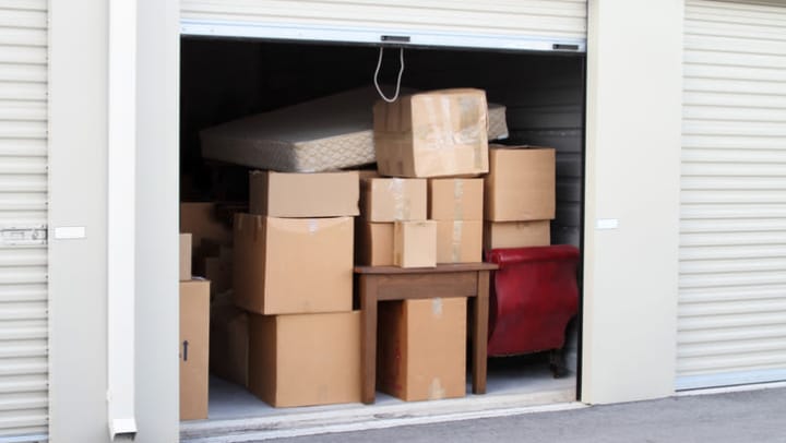 A drive-up storage unit filled with boxes and furniture.