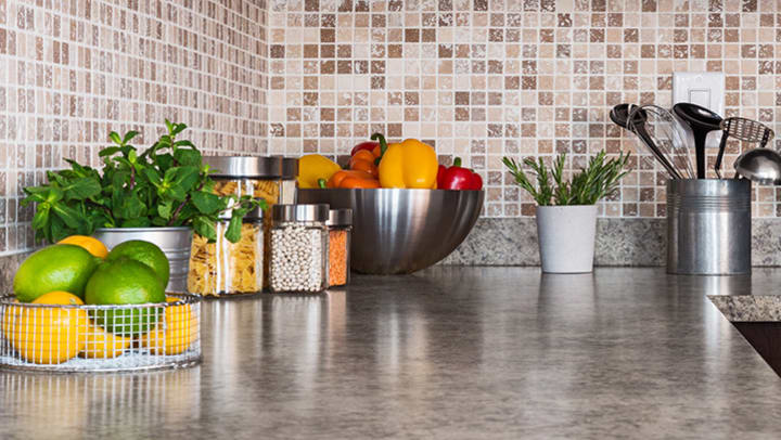 An organized kitchen counter with fruits and vegetables.