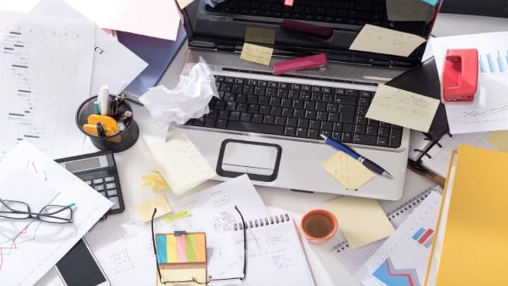 Messy office desk covered with papers.