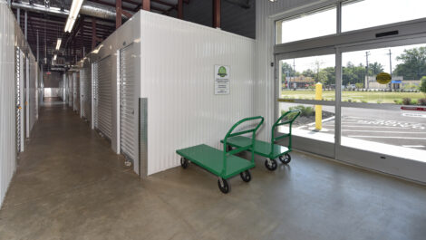White Indoor Storage Units with Garage like Doors, Large Entrance Door and Carts.