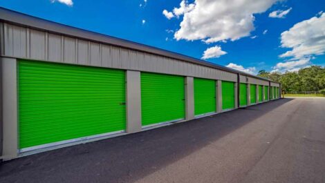 Outdoor Storage Units with Green garage like Doors.