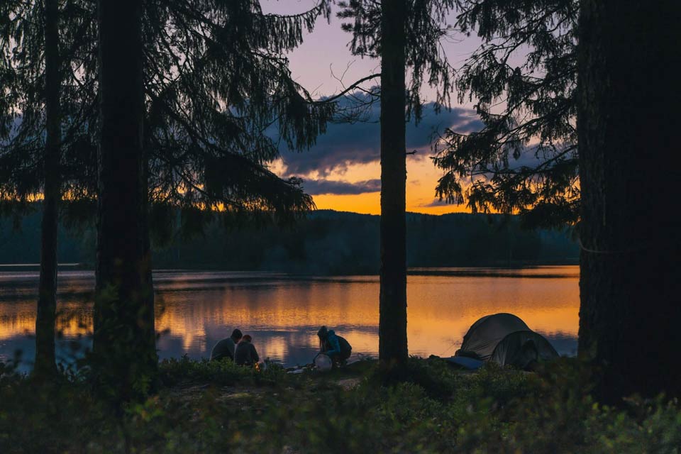 family sitting text to their text on a campground during sunset