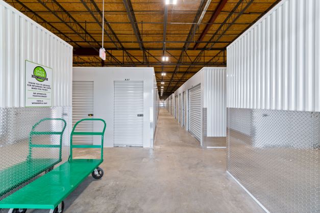 Inside of storage facility looking down hallway of indoor storage facility with storage carts on the side.