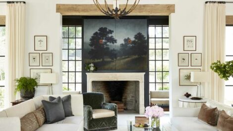 Living room with two couches and outdoor painting hanging over fireplace.