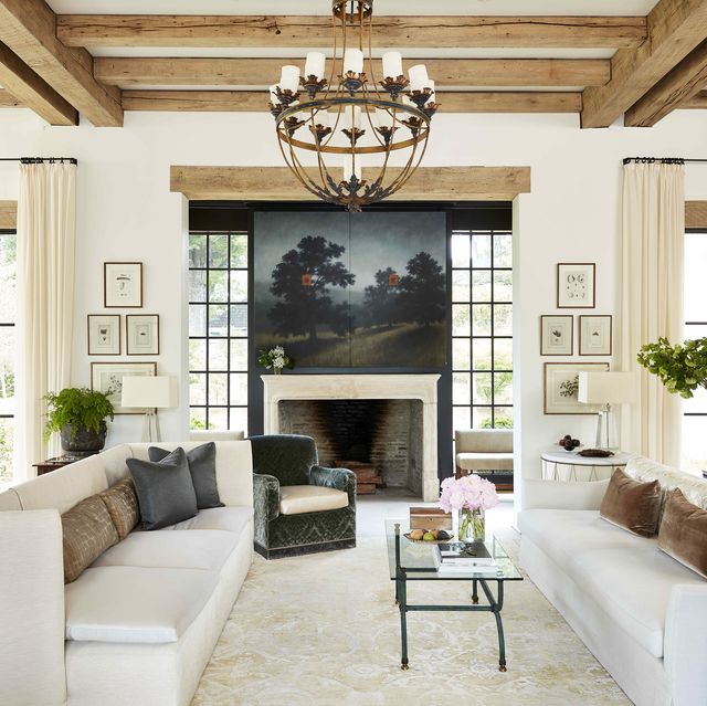 Living room with two couches and outdoor painting hanging over fireplace.