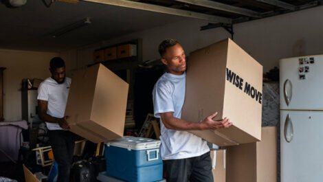 Two men moving storage boxes.