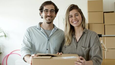Couple smiling with their moving boxes.