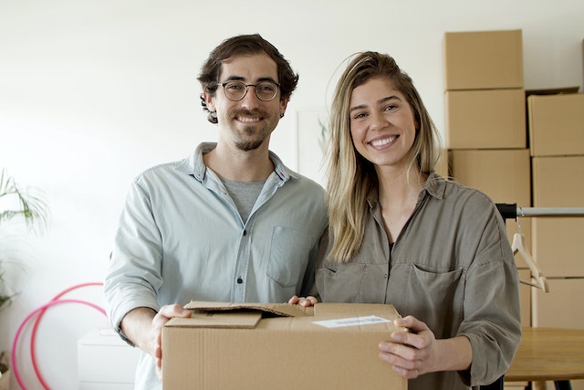 Couple smiling with their moving boxes.