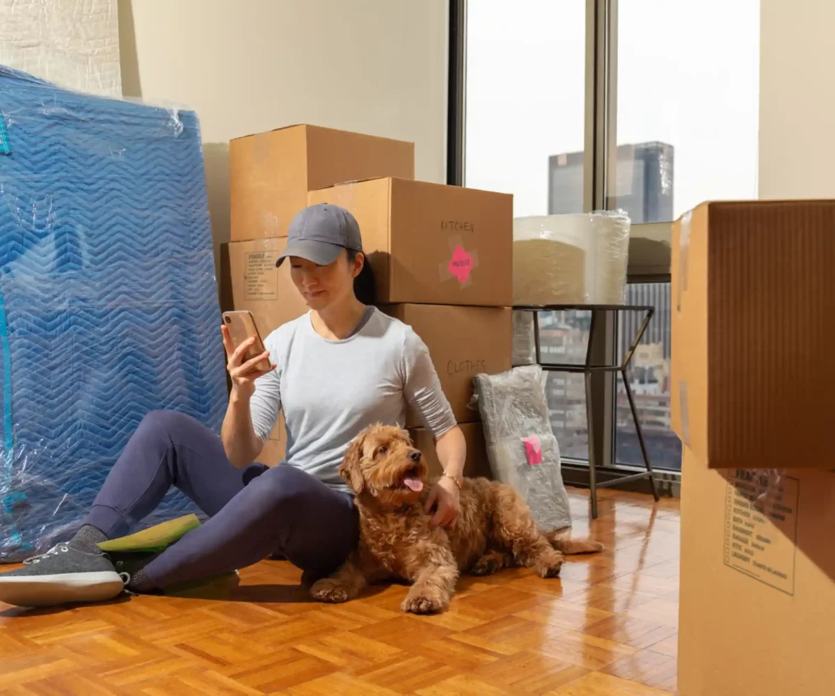 A woman and her dog with moving boxes