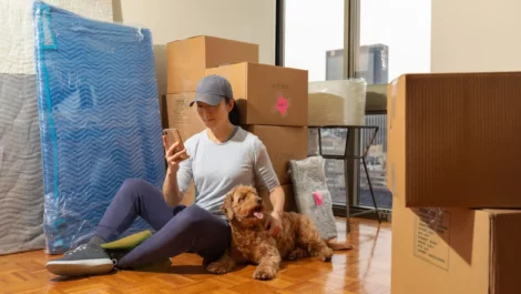 A woman and her dog with moving boxes