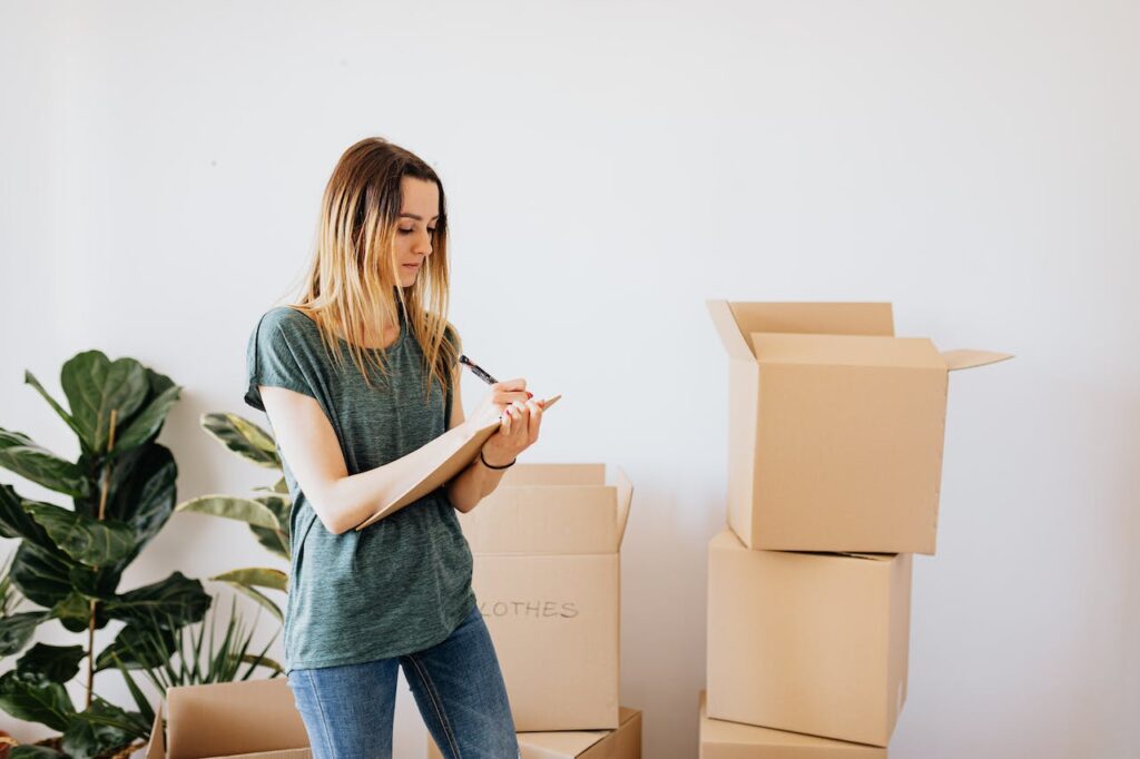 A woman writing an inventory of the things she's putting in storage.